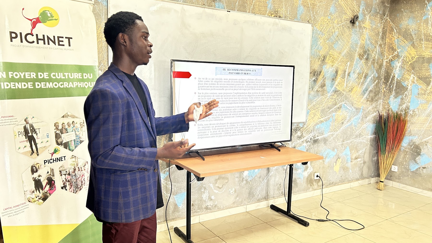 A PICHNET participant presenting recommendations beside a PICHNET banner.