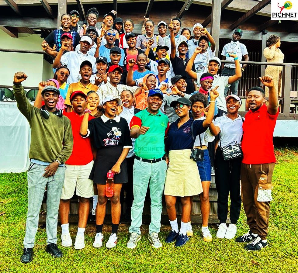 A large PICHNET internship cohort gathered together outdoors on a golf course.