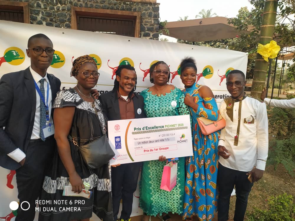 A group posing with a PICHNET excellence award at a public event.
